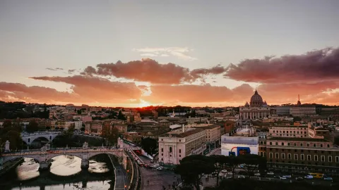 Tetti di Roma al tramonto con la cupola di San Pietro